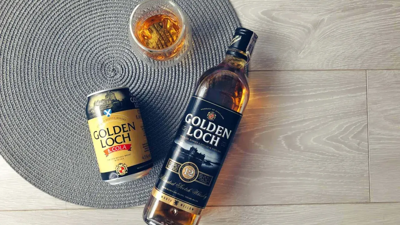 Złoty **Golden Loch** whisky i napój z colą, gotowe do degustacji.