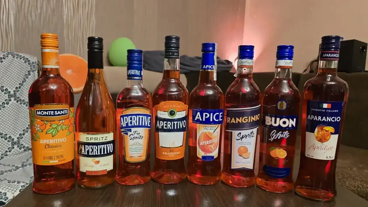 Rząd butelek z pomarańczowym, lekkim alkoholem, idealnym na letnie wieczory. Wśród nich Monte Santi, Aperitivo, Apice, Ranginino, Buon Spritz i Aparancio.