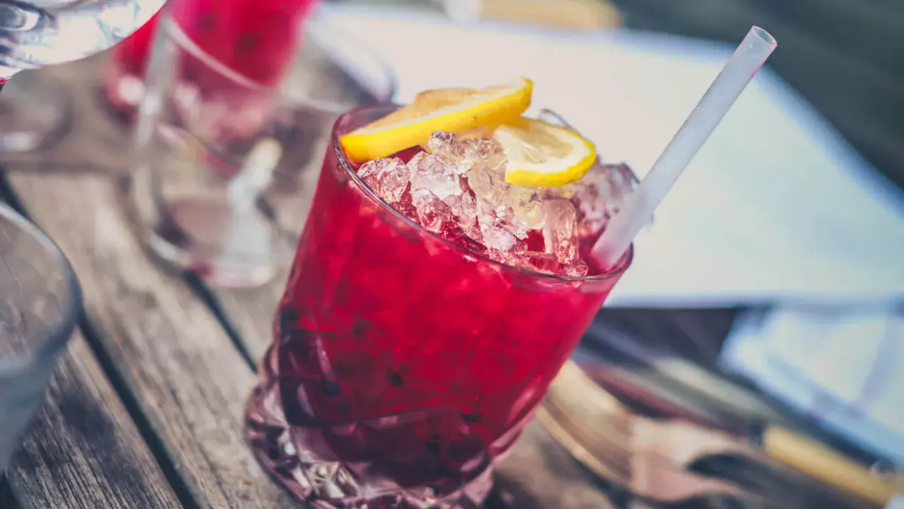 Czerwony drink z lodem i cytryną, z pewnością zawiera grenadynę. Co to jest? Syrop z granatów, idealny do koktajli.