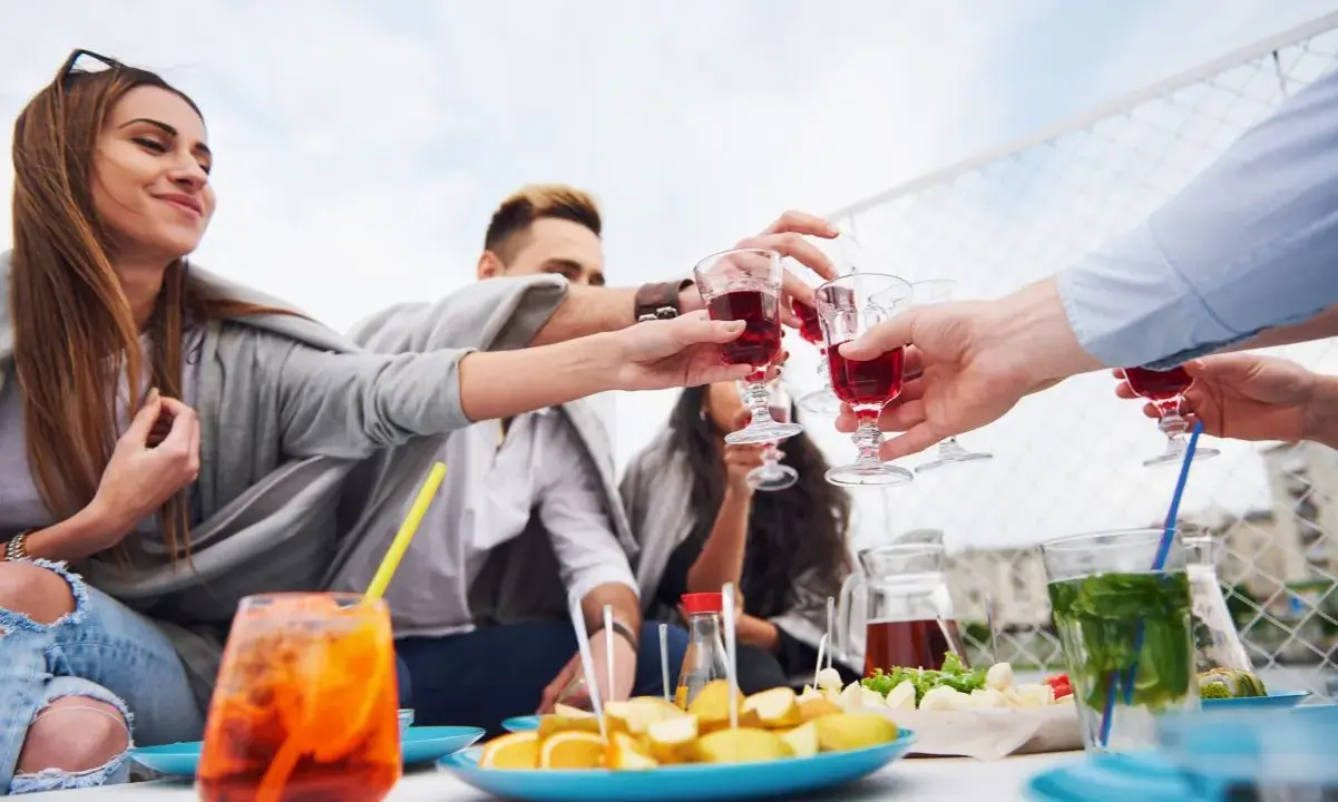 Grupa przyjaciół wznosi toast czerwonymi drinkami. Czy to już czas na digestif?