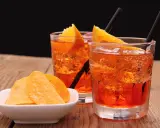 Dwa orzeźwiające drinki z pomarańczą i słone chipsy. Idealny aperitif, by rozpocząć wieczór.