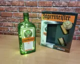 Butelka Jägermeistera z lampkami i zestawem kieliszków. Poznaj, jak smakuje jagermeister – ziołowy eliksir.