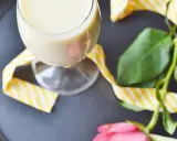 Kremowy likier bananowy w kieliszku, ozdobiony żółto-białą wstążką. Idealny na deser, jak z przepisu na likier bananowy.