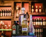 Butelki alkoholi na półce barowej: Jägermeister, tequila El Jimador, Absolut i Hypnotiq. Czy wiesz, whisky ile procent ma?