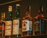 Rząd butelek whisky: Laphroaig, Jim Beam i Jack Daniel's.