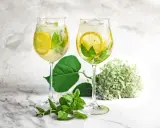 Dwa orzeźwiające drinki Hugo z syropem z czarnego bzu, cytryną i miętą, gotowe do degustacji.