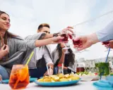Grupa przyjaciół wznosi toast czerwonymi drinkami. Czy to już czas na digestif?