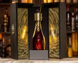 Elegancka, złota butelka z 30 letnią whisky Eagle Rare w ozdobnym, drewnianym pudełku z motywem piór.