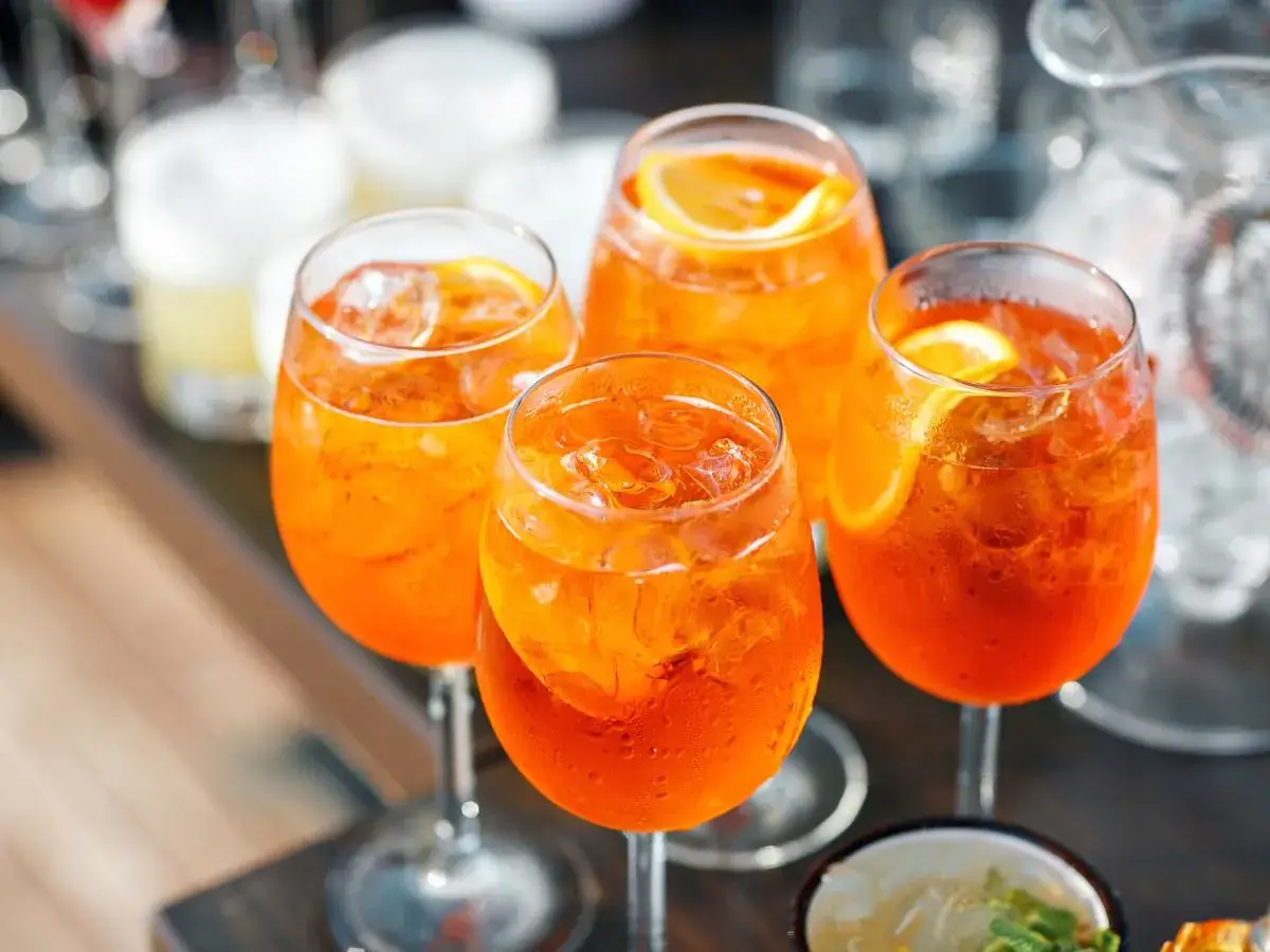 Orzeźwiające Aperol Spritz, idealne na lato. Prosty aperol przepis na drinka z lodem i plasterkiem pomarańczy.