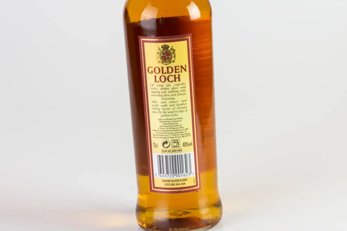 Butelka whisky Golden Loch, z etykietą opowiadającą o szkockich krajobrazach i marzeniach nad brzegiem złotych jezior.