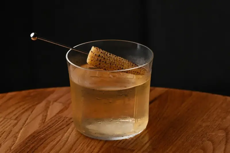 Szklanka z drinkiem i kawałkiem kukurydzy, intrygująca zapowiedź tego, jak smakuje brandy.